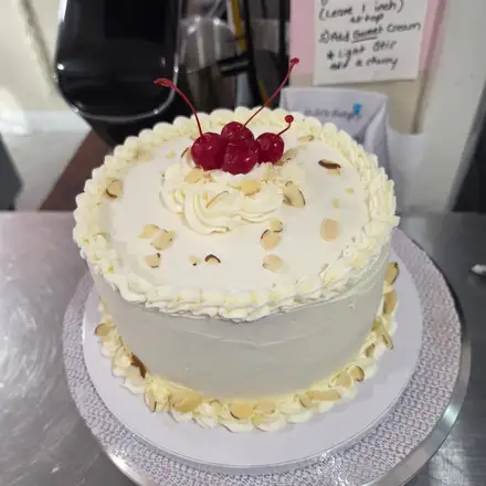 White cake with cherries and almonds