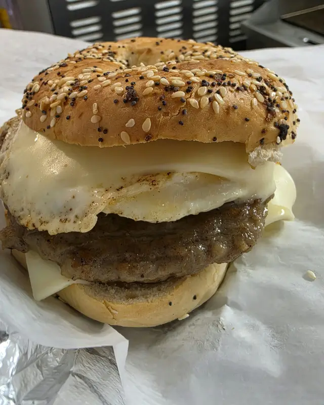 A breakfast sandwich with egg, sausage and cheese on an everything bagel